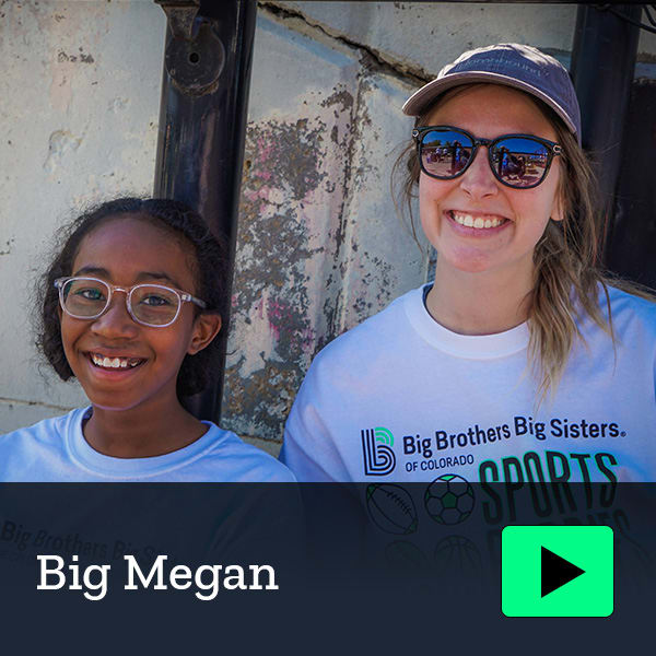 Mentor and mentee smiling outdoors.